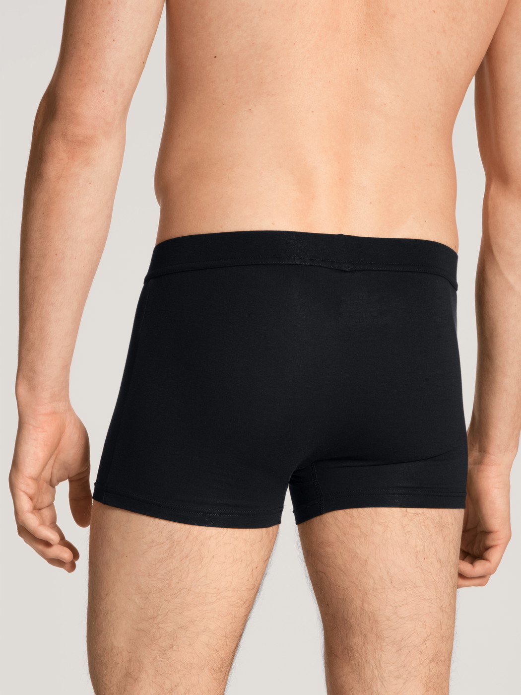 La modella / Il modello Uomo indossa Boxer brief in Cotone di colore Nero, Tinta unita, della serie Cotton Code di CALIDA, Vista posteriore
