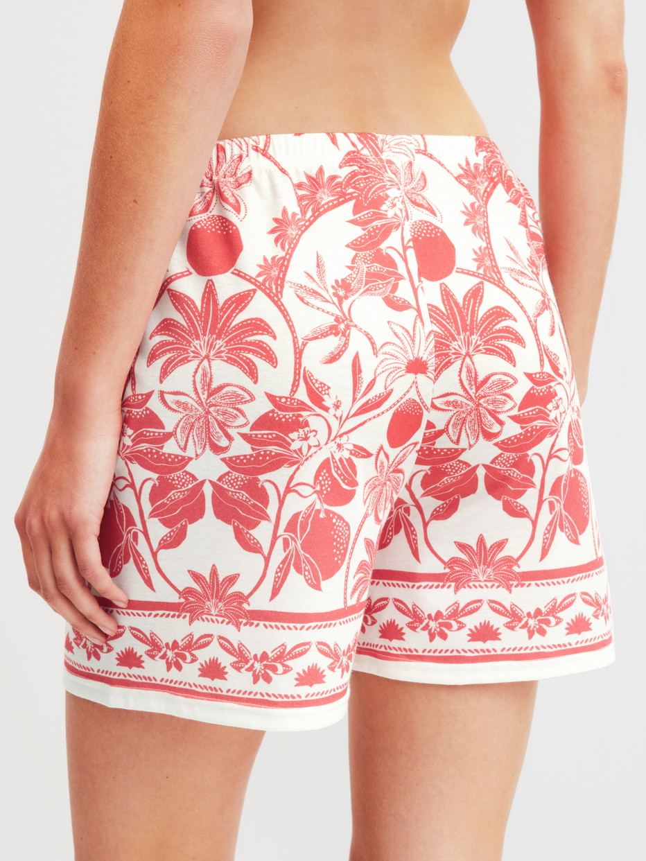 Damen-Model trägt Kurze Pyjamahose aus 100% Baumwolle in Orange, Floral aus Serie Favourites Beach von CALIDA, Rückansicht