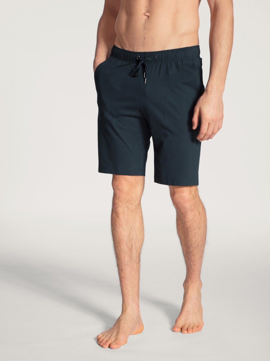 Herren-Model trägt Bermudas aus 100% Baumwolle in Blau, Einfarbig aus Serie Remix Basic Sleep von CALIDA, Vorderansicht