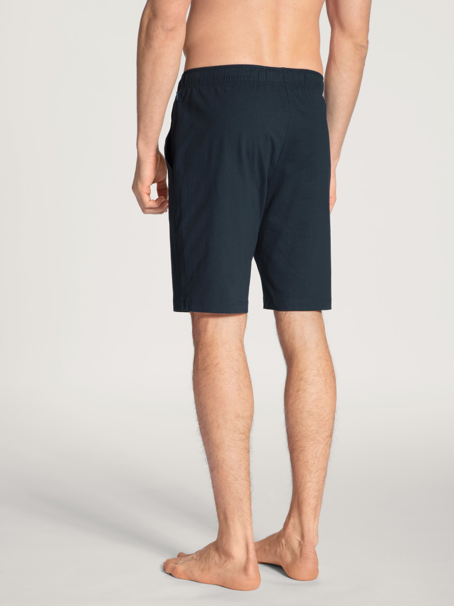 Herren-Model trägt Bermudas aus 100% Baumwolle in Blau, Einfarbig aus Serie Remix Basic Sleep von CALIDA, Rückansicht