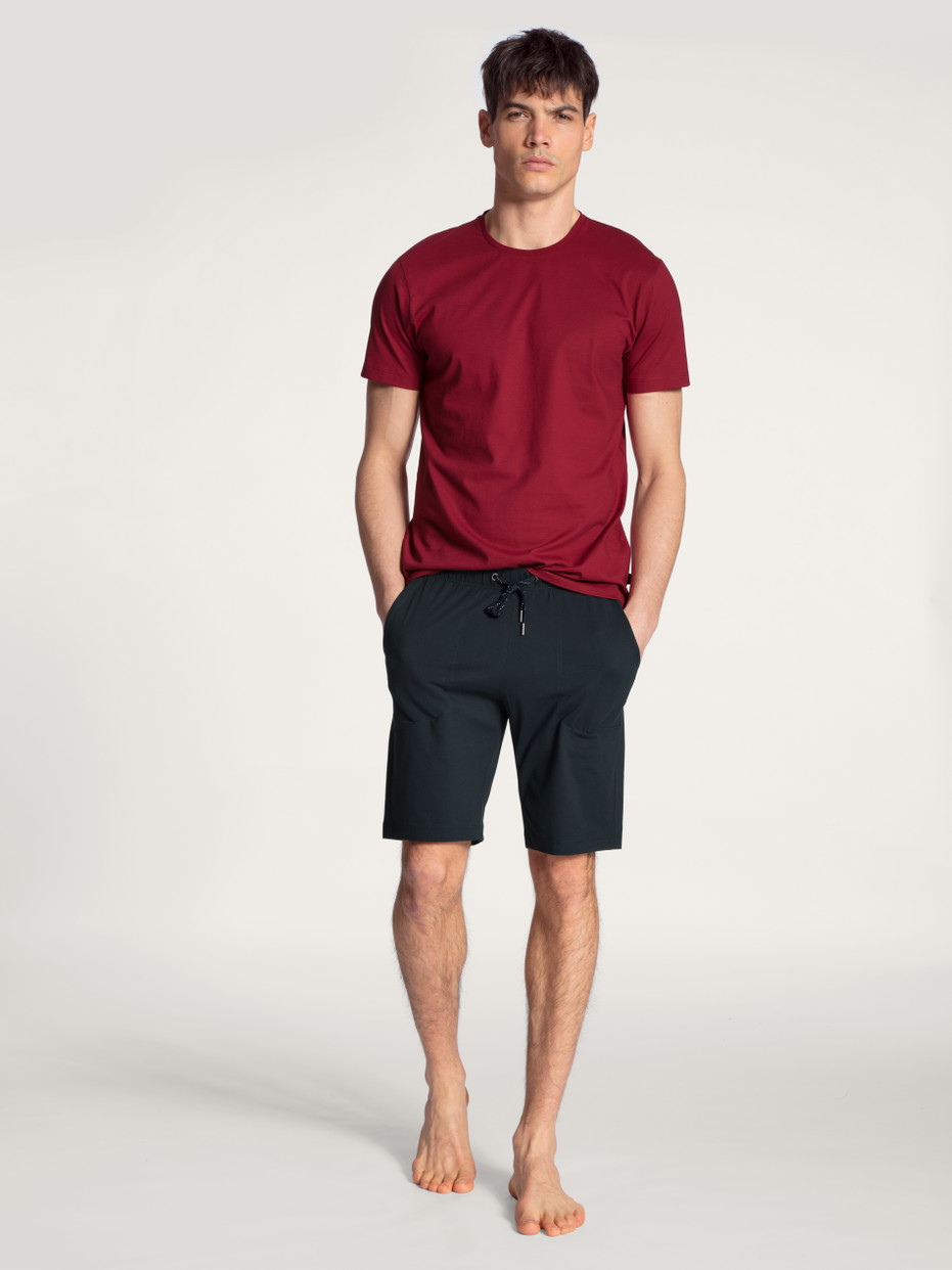 Herren-Model trägt Bermudas aus 100% Baumwolle in Blau, Einfarbig aus Serie Remix Basic Sleep von CALIDA, Outfit, Vorderansicht