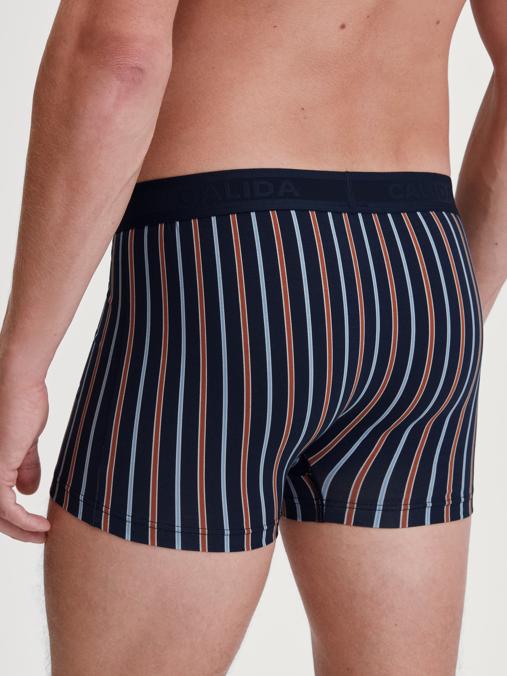 Men model is wearing Boxer brief made of Cotton in Orange, Patterned from the Grafic Cotton series by CALIDA, Back view