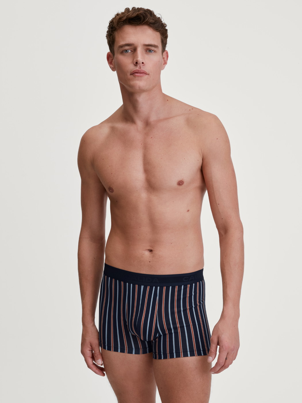 Herren-Model trägt Boxer Brief mit Softgummibund aus Baumwolle in Orange, Gemustert aus Serie Grafic Cotton von CALIDA, Outfit