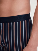 Herren-Model trägt Boxer Brief mit Softgummibund aus Baumwolle in Orange, Gemustert aus Serie Grafic Cotton von CALIDA, Detail