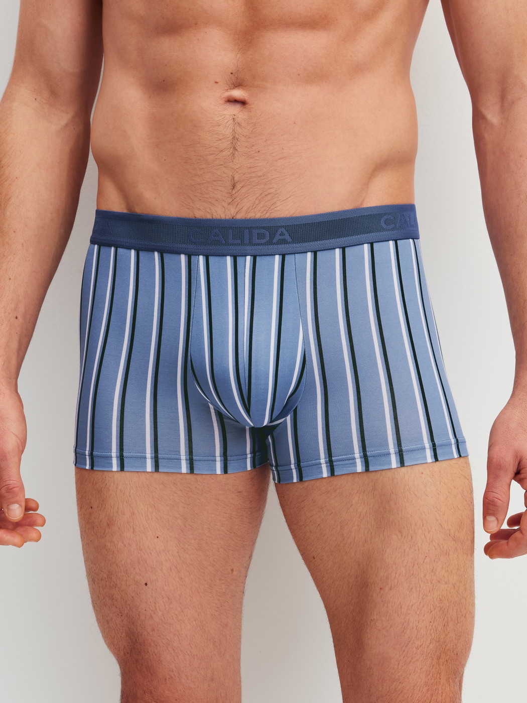 La modella / Il modello Uomo indossa Boxer brief in Pima® Cotone di colore Blu, A righe, della serie Grafic Cotton di CALIDA, Vista frontale