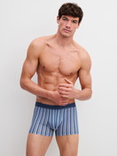 La modella / Il modello Uomo indossa Boxer brief in Pima® Cotone di colore Blu, A righe, della serie Grafic Cotton di CALIDA, Vista frontale