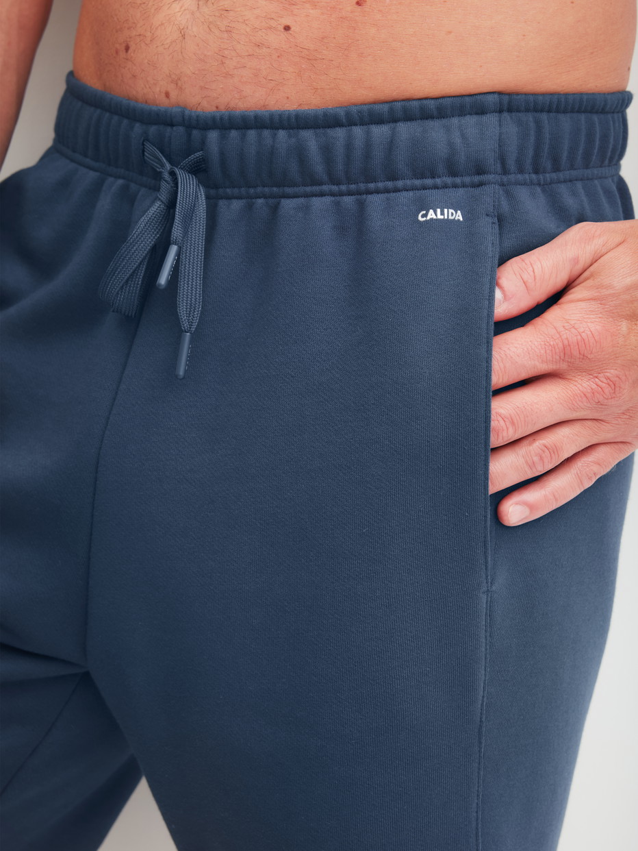 Herren-Model trägt Bermudas mit Seitentaschen aus Baumwolle in Blau, Einfarbig aus Serie RMX Lounge Journey von CALIDA, Detail