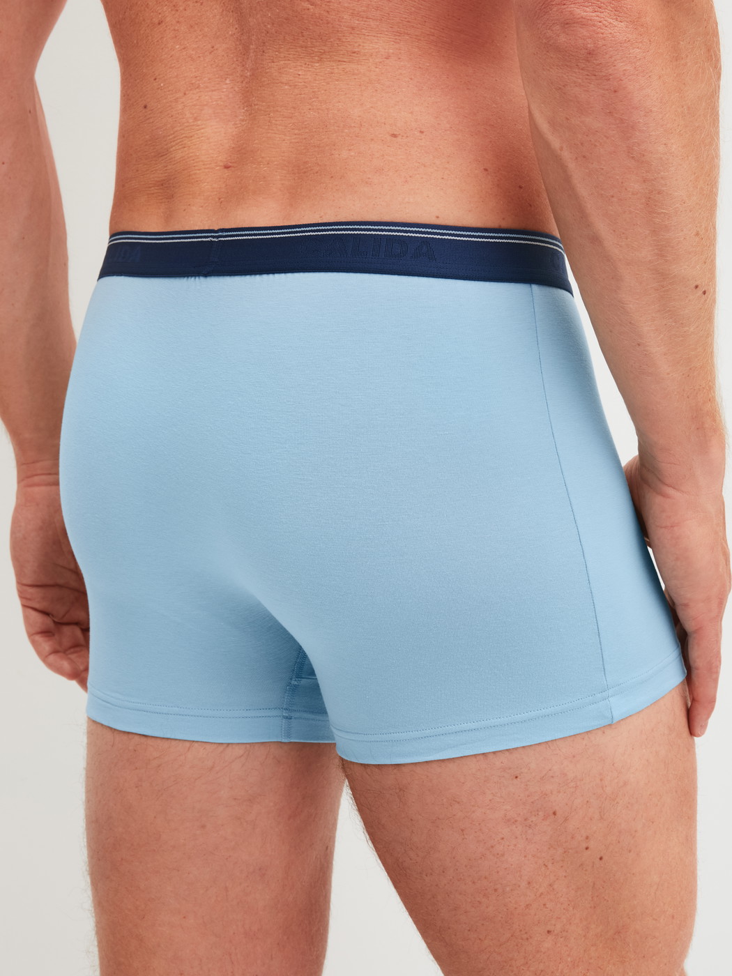 Herren-Model trägt Boxer Brief, 3er-Pack aus Baumwolle in Blau, Einfarbig aus Serie Natural Benefit von CALIDA, Rückansicht
