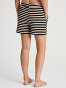 Damen-Model trägt Loungeshorts aus Baumwolle in Schwarz, Gestreift aus Serie Lounge Stripe von CALIDA, Rückansicht
