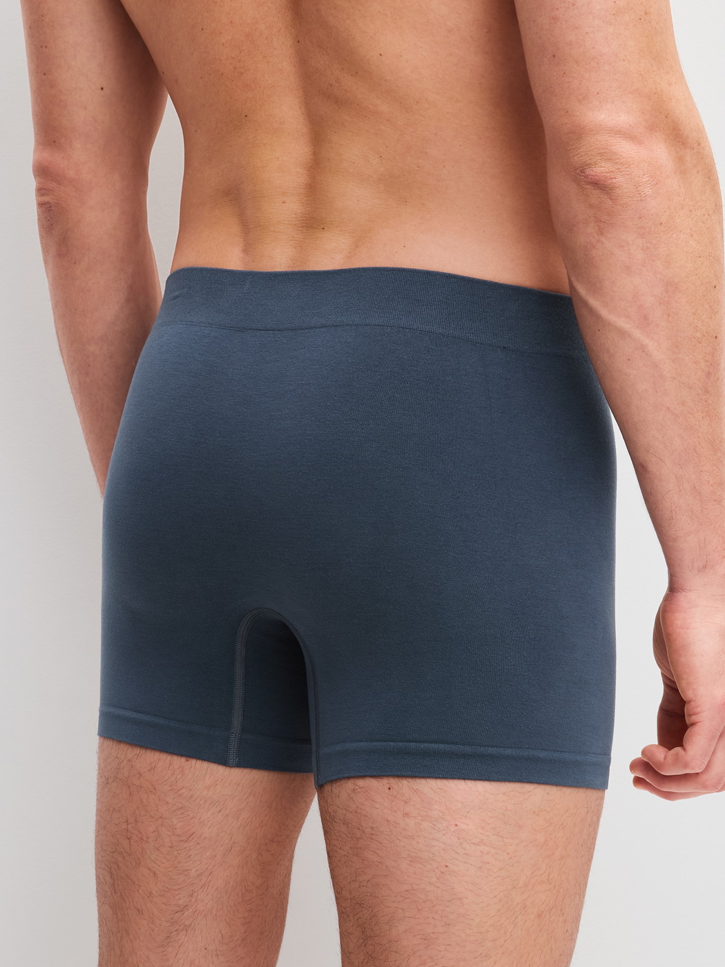Men model is wearing Boxer briefs with longer leg made of Modal in Grey, Unicoloured from the Seamless Natural series by CALIDA, Back view