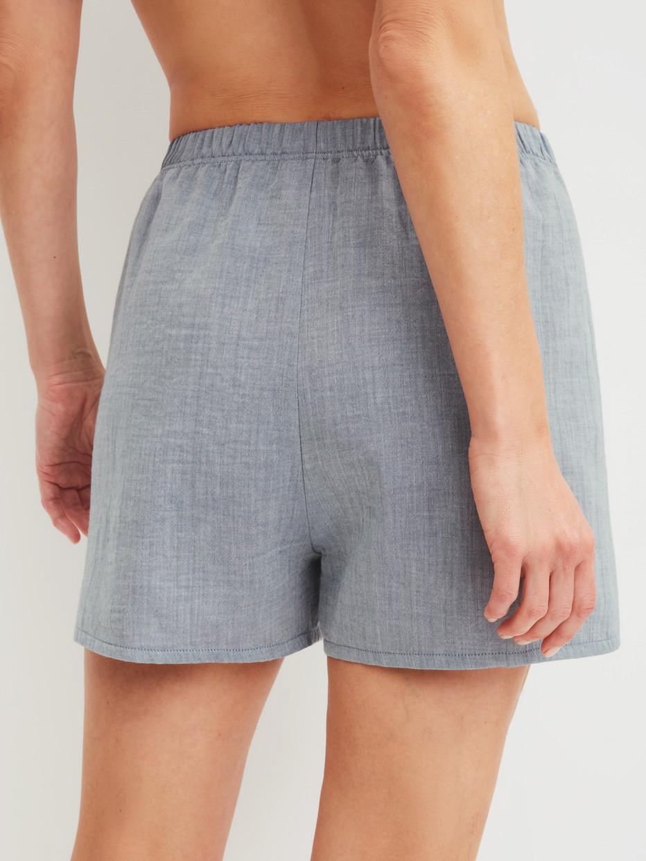 Damen-Model trägt Kurze Pyjamahose aus 100% Baumwolle in Blau, Einfarbig aus Serie Favourites Tiles von CALIDA, Rückansicht