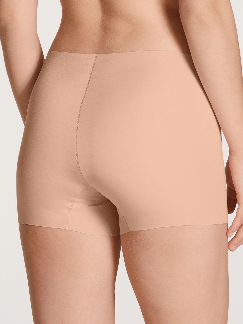 Damen-Model trägt Radlerhose mit saumlosem Beinabschnitt aus Modal in Rosa, Einfarbig aus Serie Natural Skin von CALIDA, Rückansicht