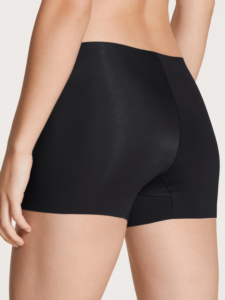 Damen-Model trägt Radlerhose mit saumlosem Beinabschnitt aus Modal in Schwarz, Einfarbig aus Serie Natural Skin von CALIDA, Rückansicht