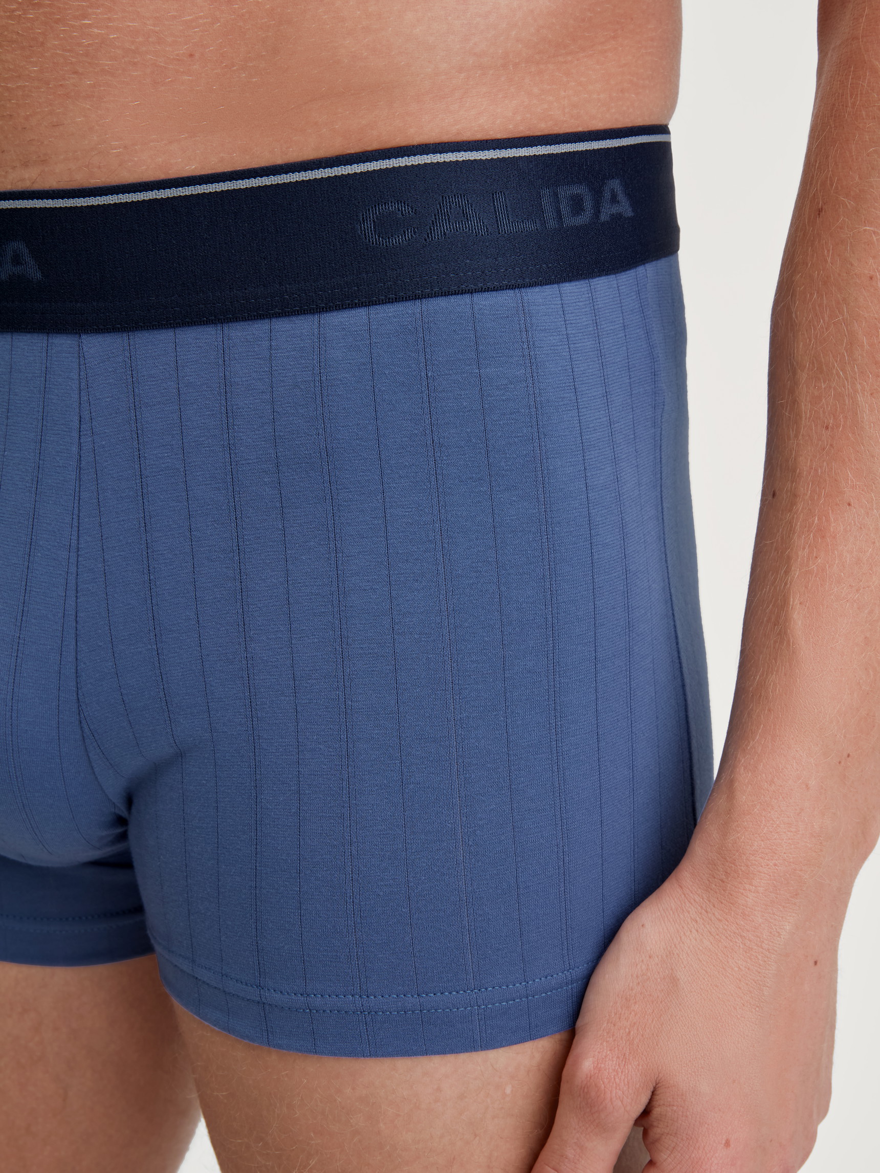 Herren-Model trägt Boxer Brief mit Elastikbund aus Baumwolle in Blau, Einfarbig aus Serie Pure & Style von CALIDA, Detail