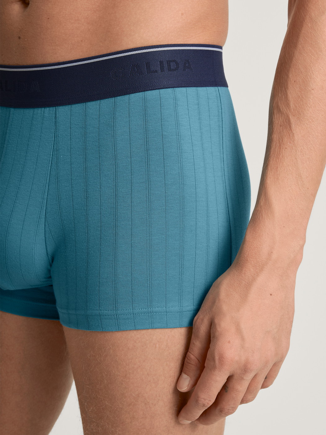 Herren-Model trägt Boxer Brief mit Elastikbund aus Baumwolle in Türkis, Einfarbig aus Serie Pure & Style von CALIDA, Detail