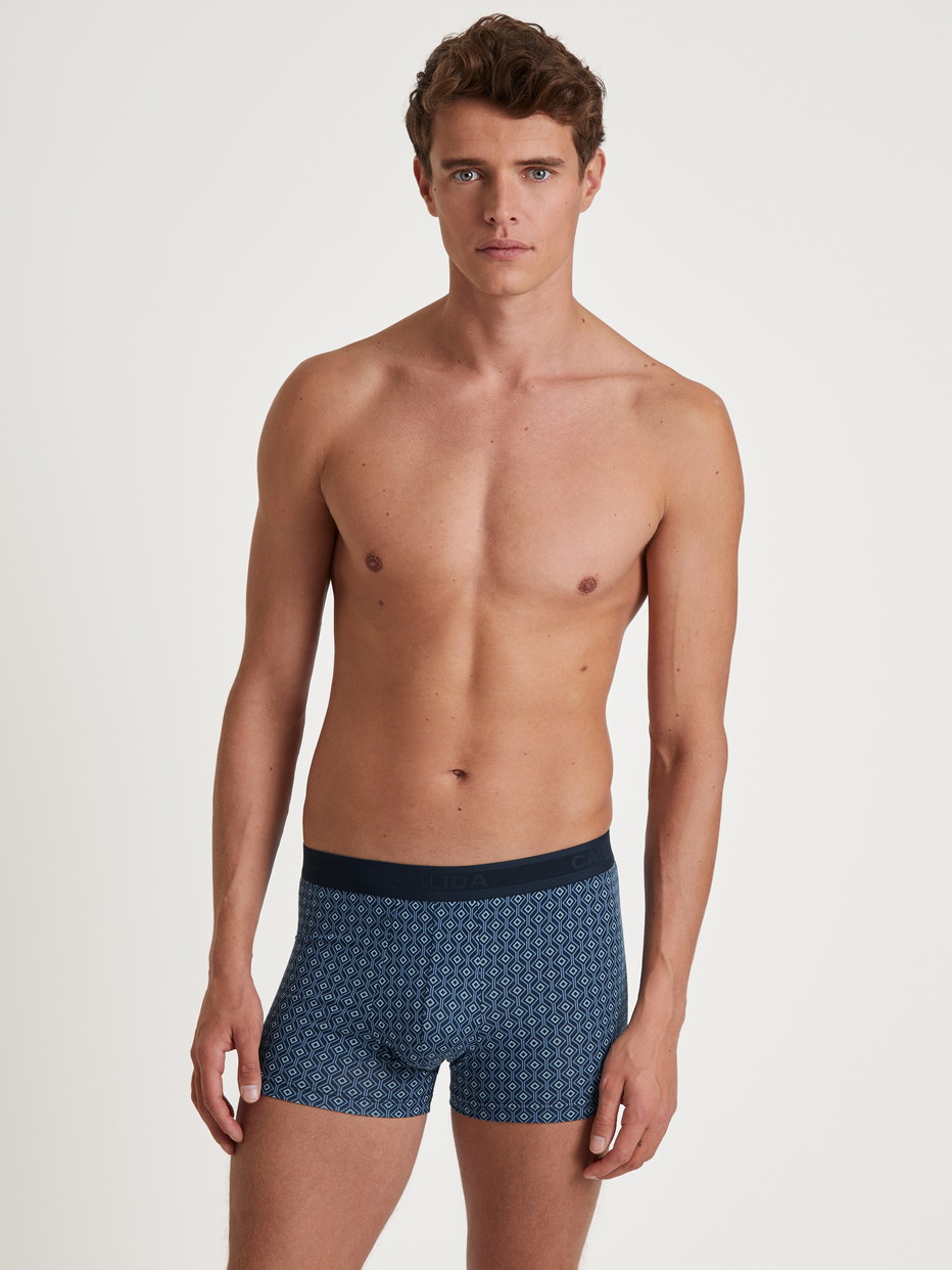 Herren-Model trägt Boxer Brief mit Softgummibund aus Baumwolle in Blau, Motiv aus Serie Grafic Cotton von CALIDA, Outfit