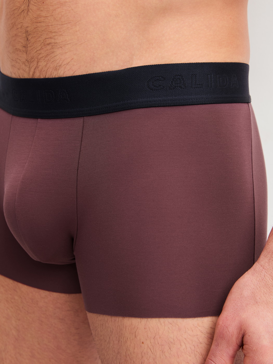 Herren-Model trägt Boxer Brief mit Softbund aus Modal in Rot, Einfarbig aus Serie Clean Line von CALIDA, Detail