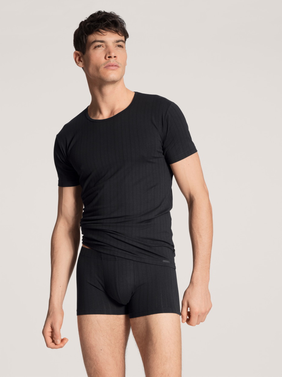 Herren-Model trägt Boxer Brief mit überzogenem Bund aus Baumwolle in Schwarz, Einfarbig aus Serie Pure & Style von CALIDA, Outfit, Vorderansicht