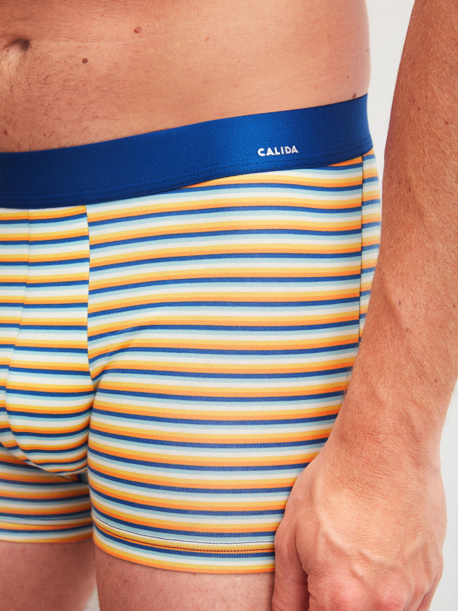 Herren-Model trägt Boxer Brief mit Softgummibund aus Baumwolle in Orange, Gemustert aus Serie Cotton Code Design von CALIDA, Detail