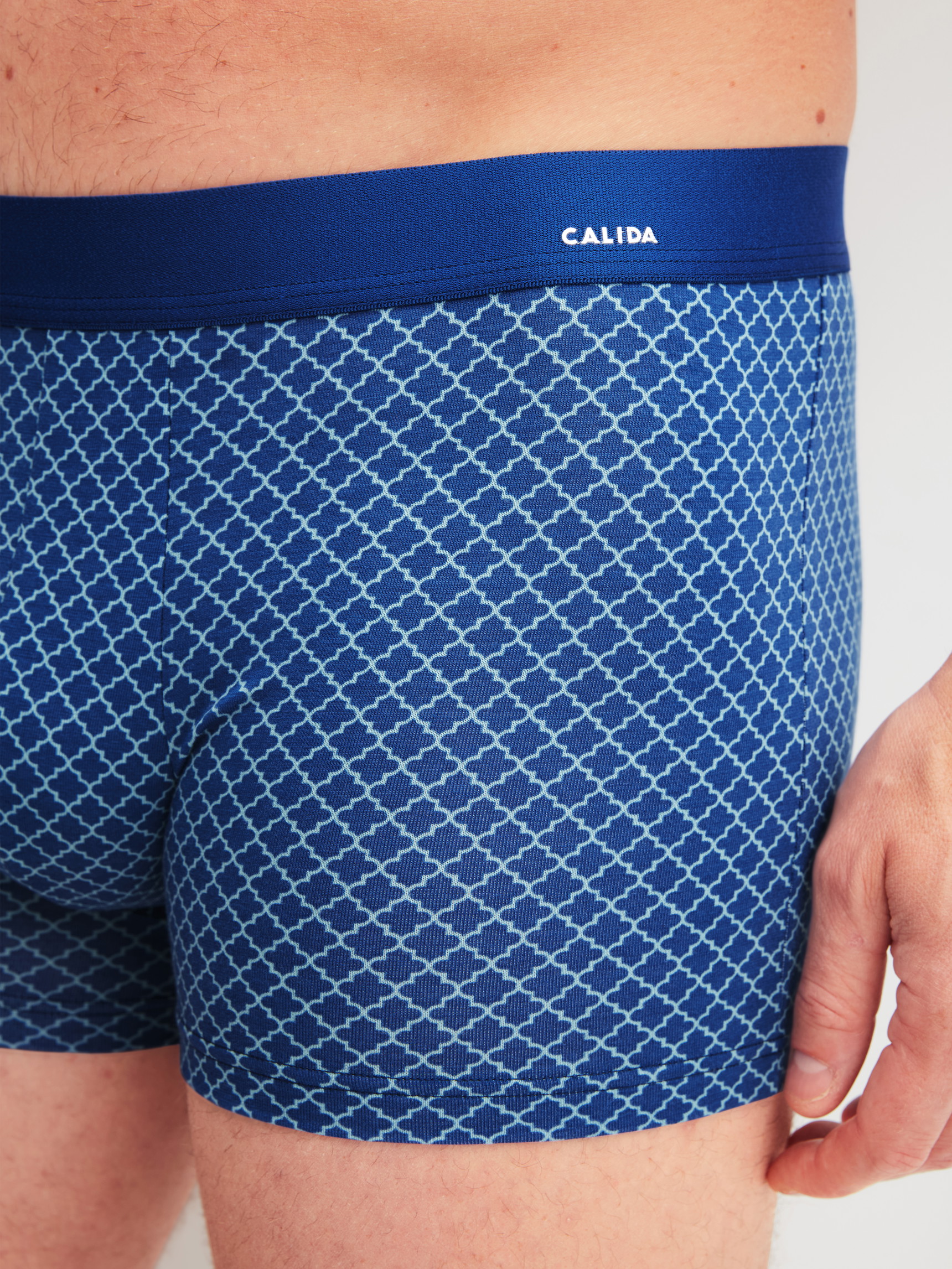 La modella / Il modello Uomo indossa Boxer brief in Cotone di colore Blu, Modello, della serie Cotton Code Design di CALIDA, Dettaglio