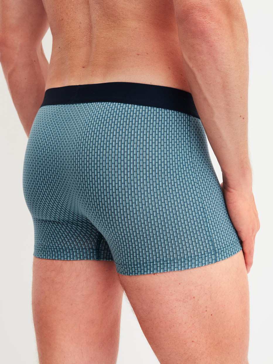 Herren-Model trägt Boxer Brief mit Softgummibund aus Baumwolle in Blau, Gemustert aus Serie Cotton Code Design von CALIDA, Rückansicht