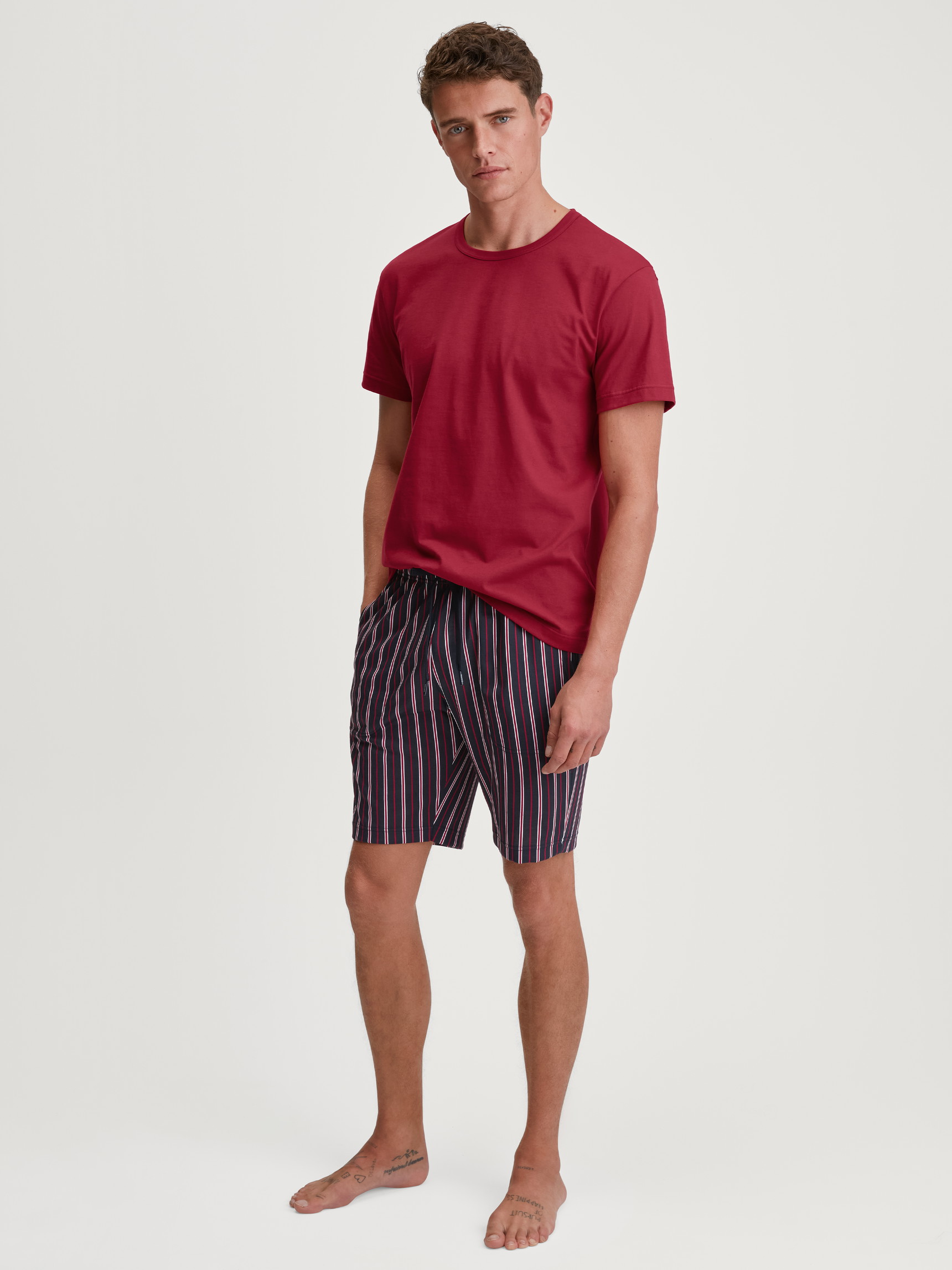 La modella / Il modello Uomo indossa Bermuda in 100% cotone di colore Rosso, A scacchi, della serie Remix Basic Sleep di CALIDA, Abbigliamento