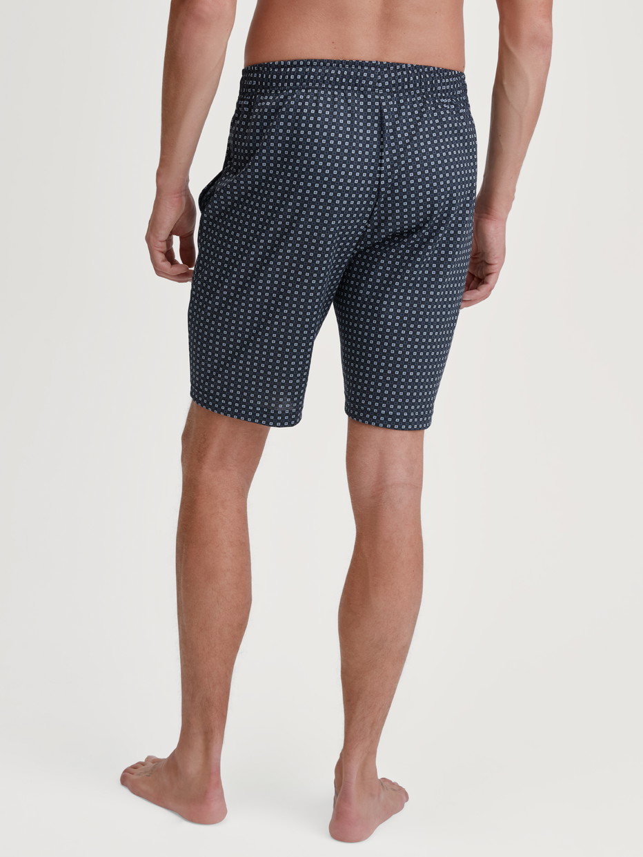 Herren-Model trägt Bermudas aus 100% Baumwolle in Blau, Kariert aus Serie Remix Basic Sleep von CALIDA, Rückansicht