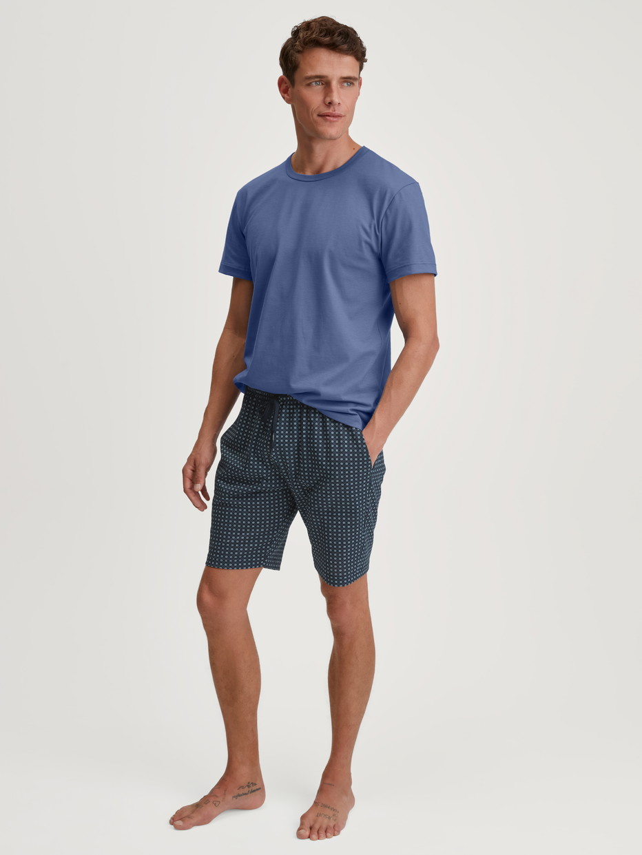 Herren-Model trägt Bermudas aus 100% Baumwolle in Blau, Kariert aus Serie Remix Basic Sleep von CALIDA, Outfit