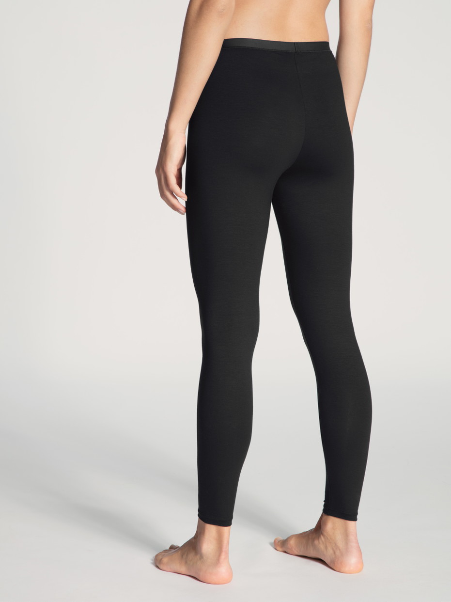 Damen-Model trägt Leggings aus Baumwolle in Schwarz, Einfarbig aus Serie Natural Comfort von CALIDA, Rückansicht