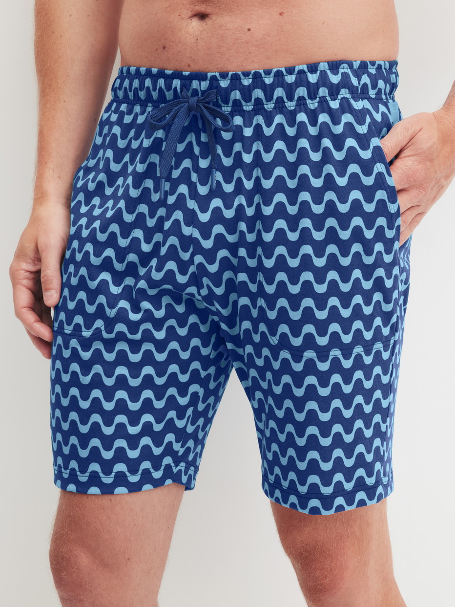 Herren-Model trägt Bermudas aus 100% Baumwolle in Blau, Gemustert aus Serie RMX Sleep Time off von CALIDA, Vorderansicht