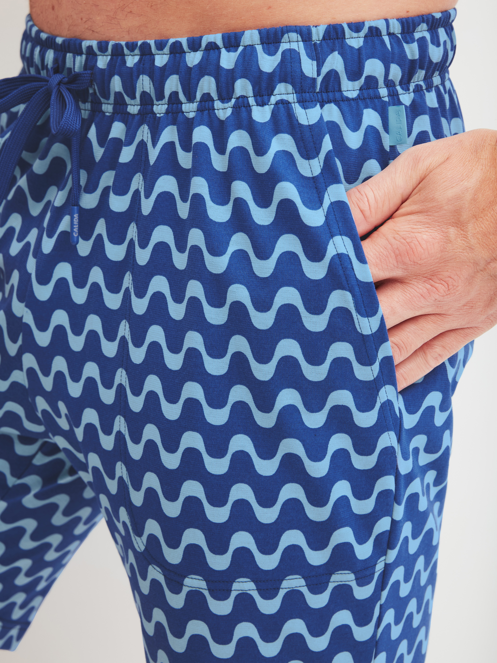 Herren-Model trägt Bermudas aus 100% Baumwolle in Blau, Gemustert aus Serie RMX Sleep Time off von CALIDA, Detail