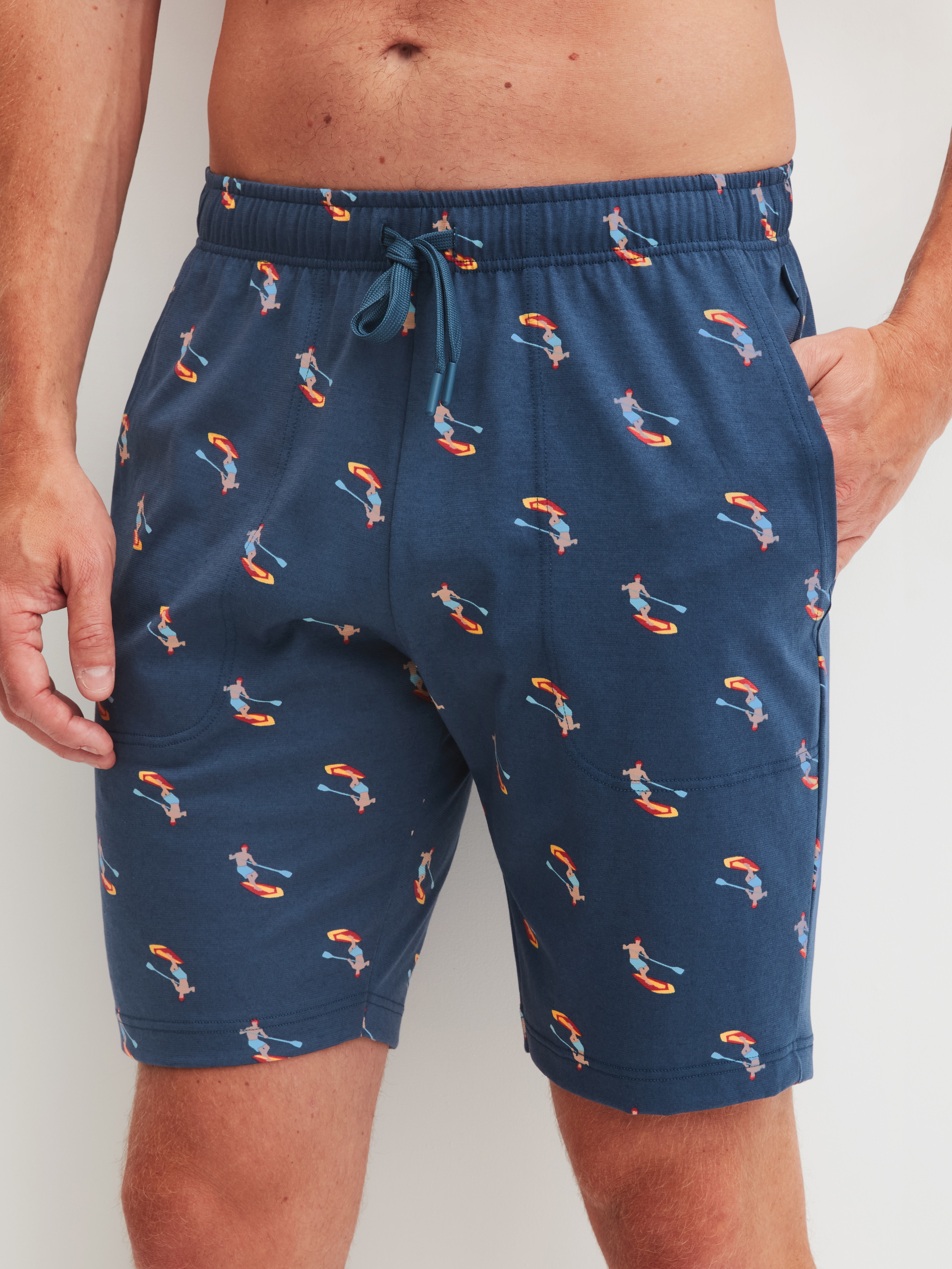 Herren-Model trägt Bermudas aus 100% Baumwolle in Blau, Gemustert aus Serie RMX Sleep Holiday von CALIDA, Vorderansicht