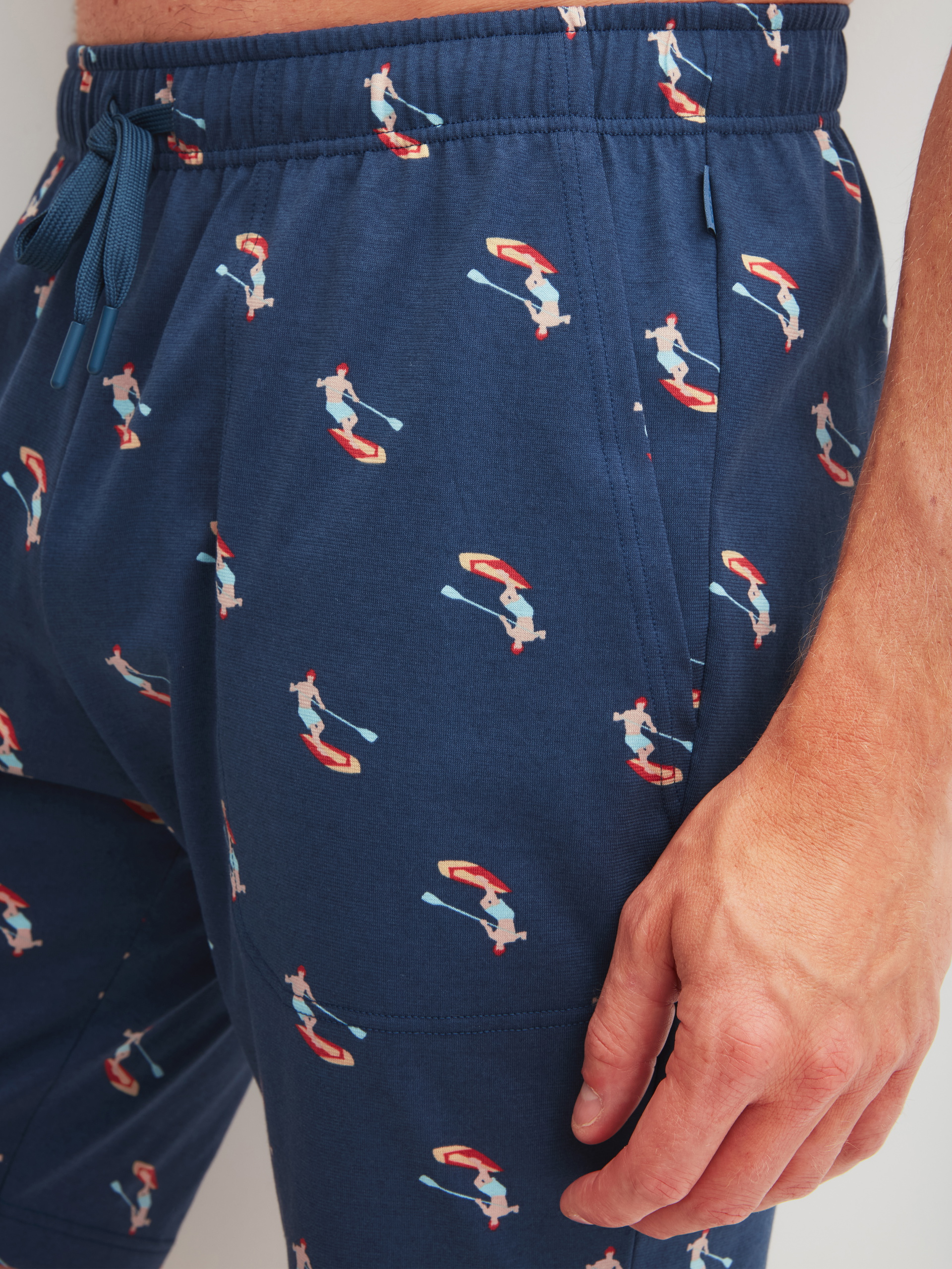 Herren-Model trägt Bermudas aus 100% Baumwolle in Blau, Gemustert aus Serie RMX Sleep Holiday von CALIDA, Detail