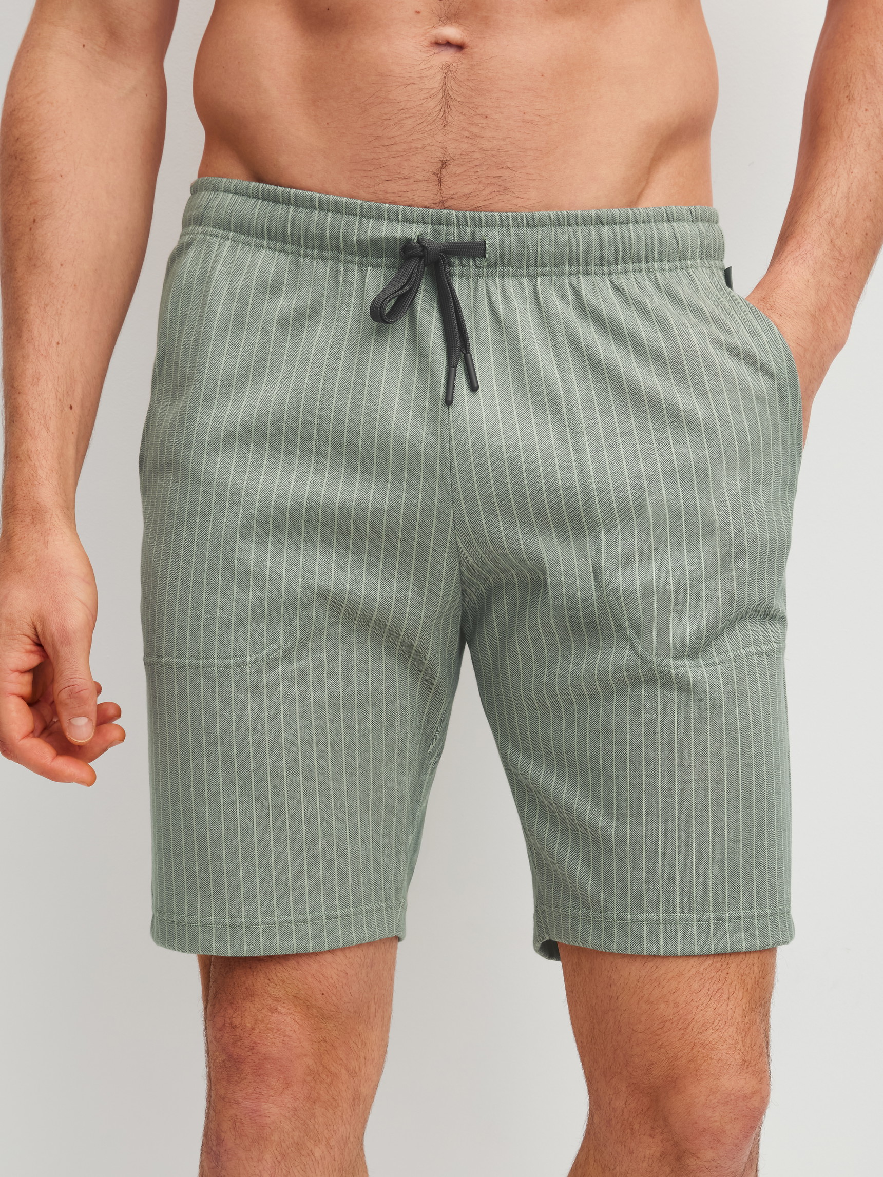 Herren-Model trägt Bermudas aus 100% Baumwolle in Grün, Einfarbig aus Serie RMX Sleep Leisure von CALIDA, Vorderansicht