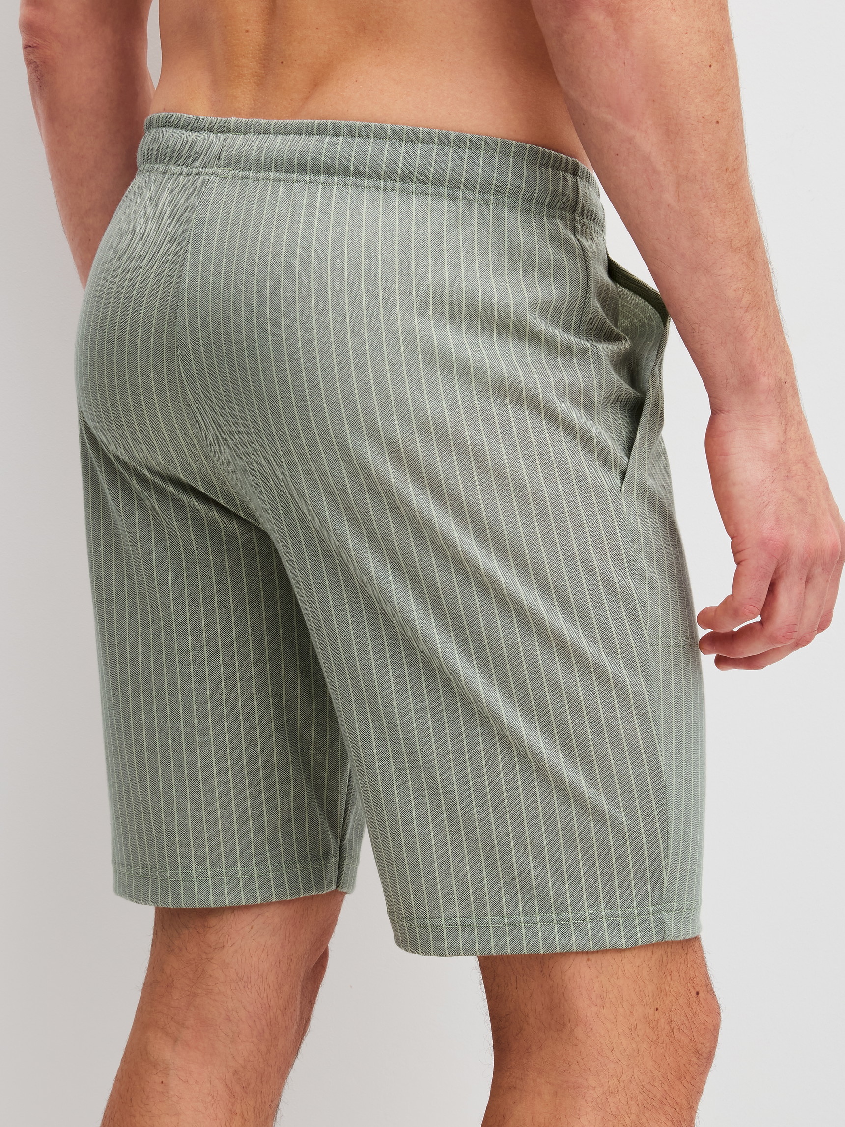 Herren-Model trägt Bermudas aus 100% Baumwolle in Grün, Einfarbig aus Serie RMX Sleep Leisure von CALIDA, Rückansicht