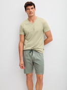 Herren-Model trägt Bermudas aus 100% Baumwolle in Grün, Einfarbig aus Serie RMX Sleep Leisure von CALIDA, Outfit