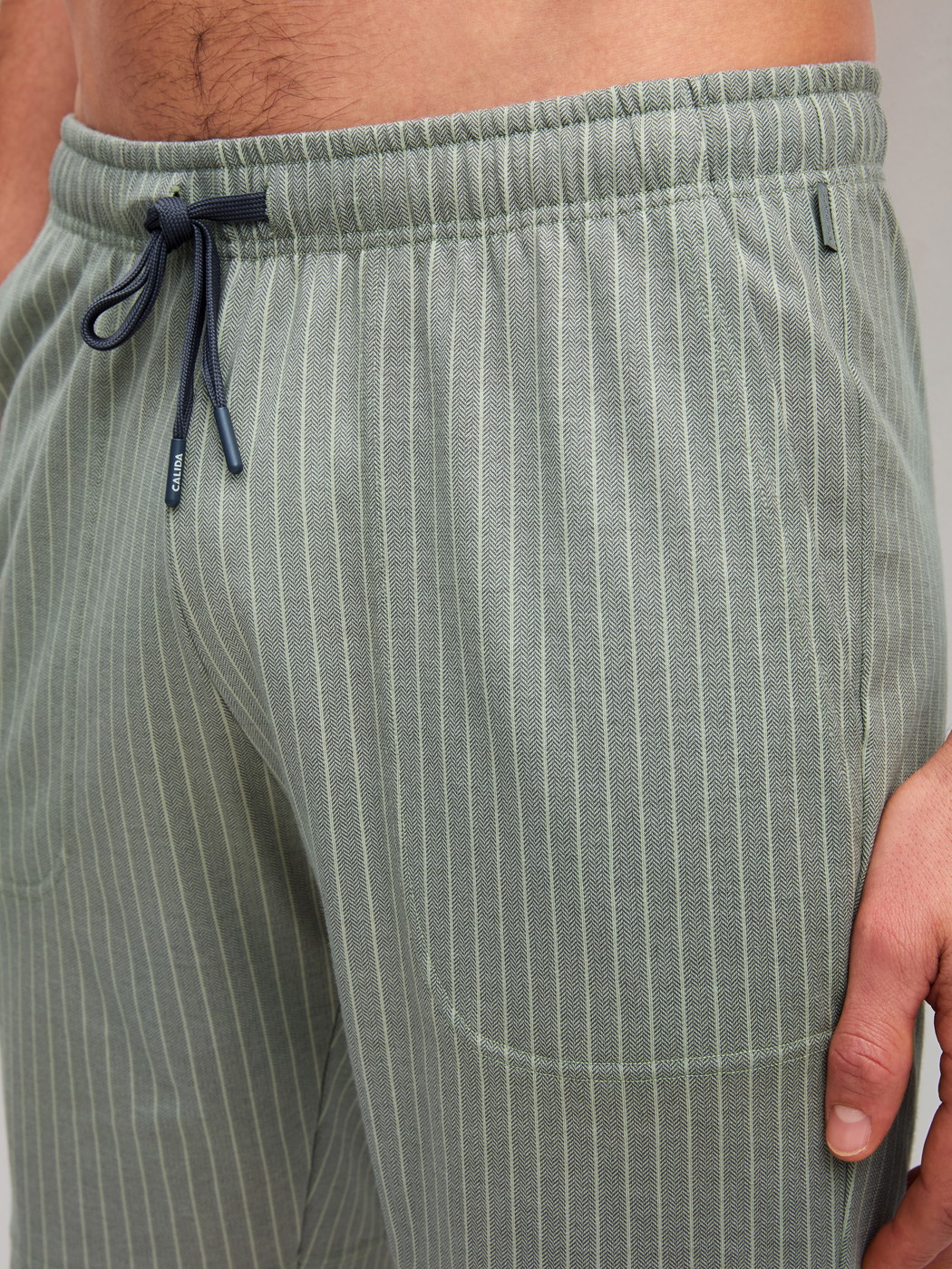 Herren-Model trägt Bermudas aus 100% Baumwolle in Grün, Einfarbig aus Serie RMX Sleep Leisure von CALIDA, Detail