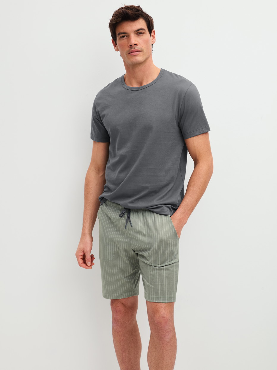 Herren-Model trägt Bermudas aus 100% Baumwolle in Grün, Einfarbig aus Serie RMX Sleep Leisure von CALIDA, Zusatzbild