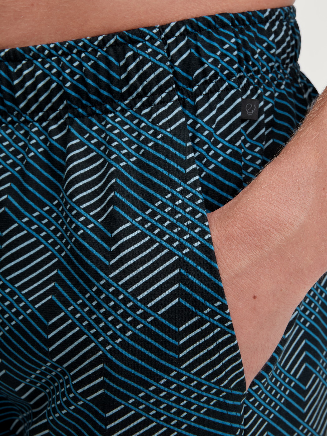 Men model is wearing Bermudas made of 100% Cotton in Black, Patterned from the RMX Sleep Leisure series by CALIDA, Detail