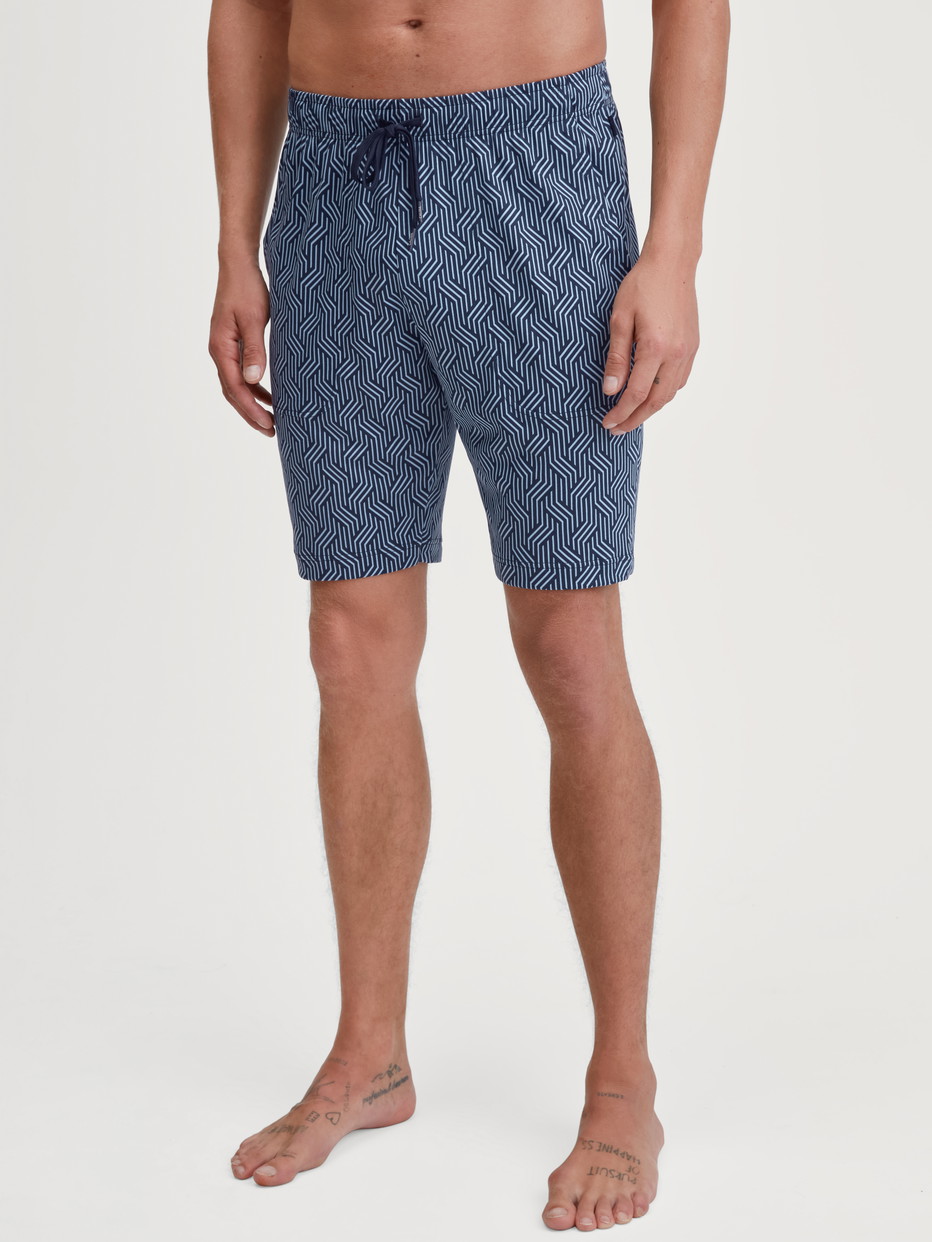 Herren-Model trägt Bermudas mit Seitentaschen aus Baumwolle in Blau, Gemustert aus Serie RMX Sleep Free von CALIDA, Vorderansicht
