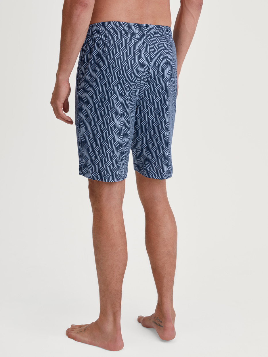 Herren-Model trägt Bermudas mit Seitentaschen aus Baumwolle in Blau, Gemustert aus Serie RMX Sleep Free von CALIDA, Rückansicht