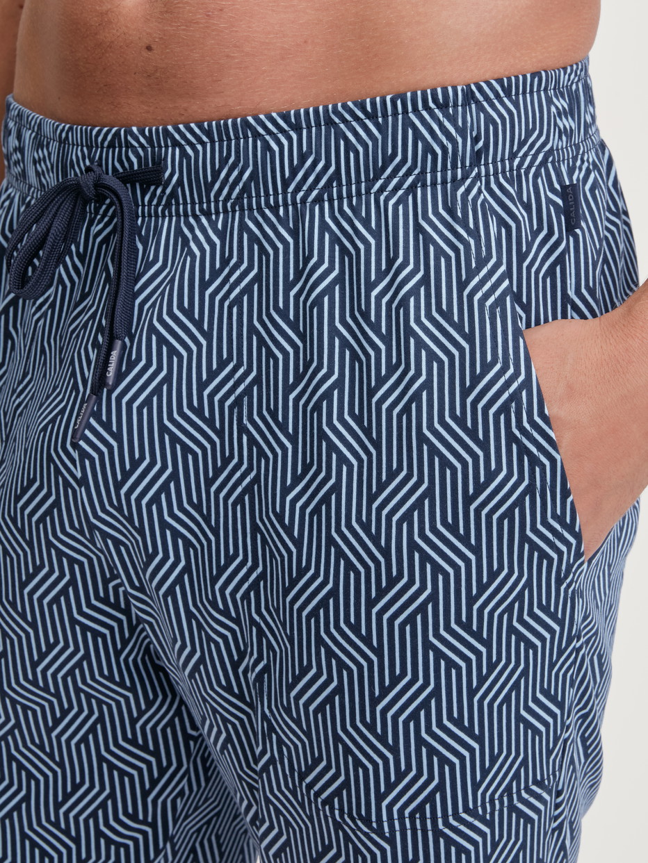 Herren-Model trägt Bermudas mit Seitentaschen aus Baumwolle in Blau, Gemustert aus Serie RMX Sleep Free von CALIDA, Detail