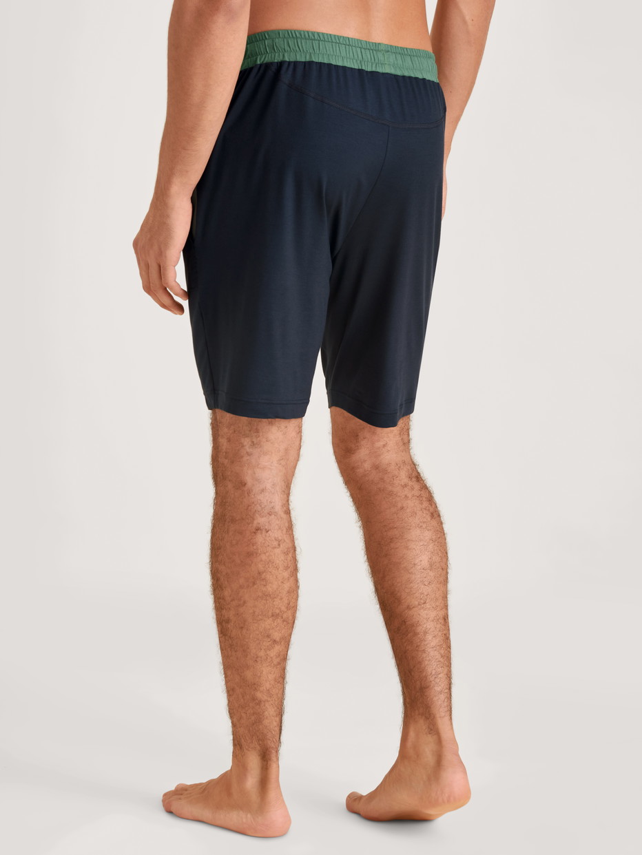 Herren-Model trägt Bermudas aus Modal in Blau, Einfarbig aus Serie DSW Balancing von CALIDA, Rückansicht