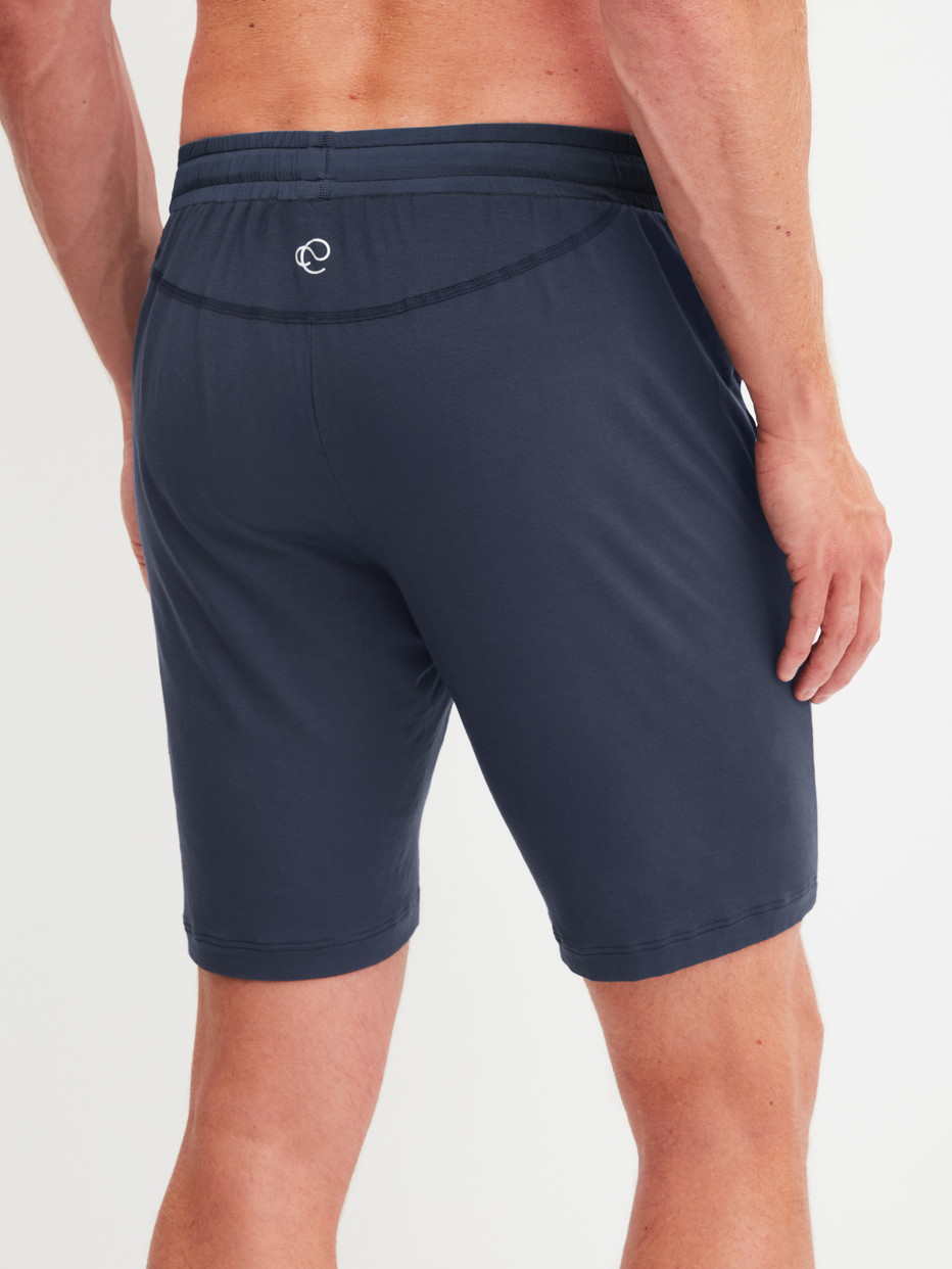 Herren-Model trägt Bermudas aus Modal in Blau, Einfarbig aus Serie DSW Balancing von CALIDA, Rückansicht