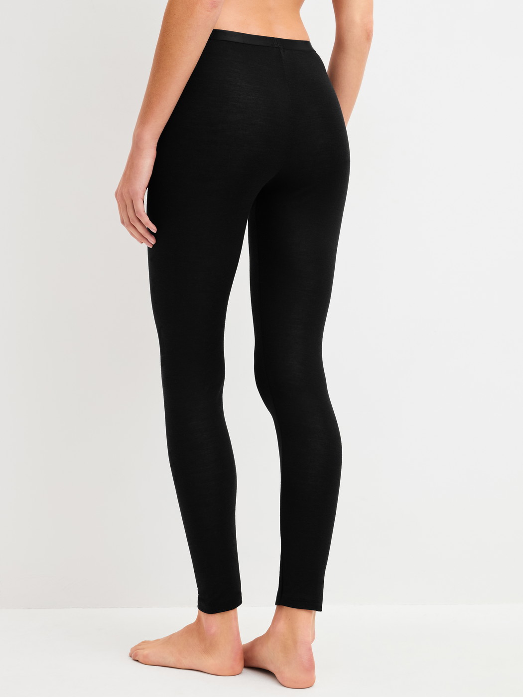 Damen-Model trägt Leggings aus Wolle-Seide aus Wolle in Schwarz, Einfarbig aus Serie True Confidence von CALIDA, Rückansicht