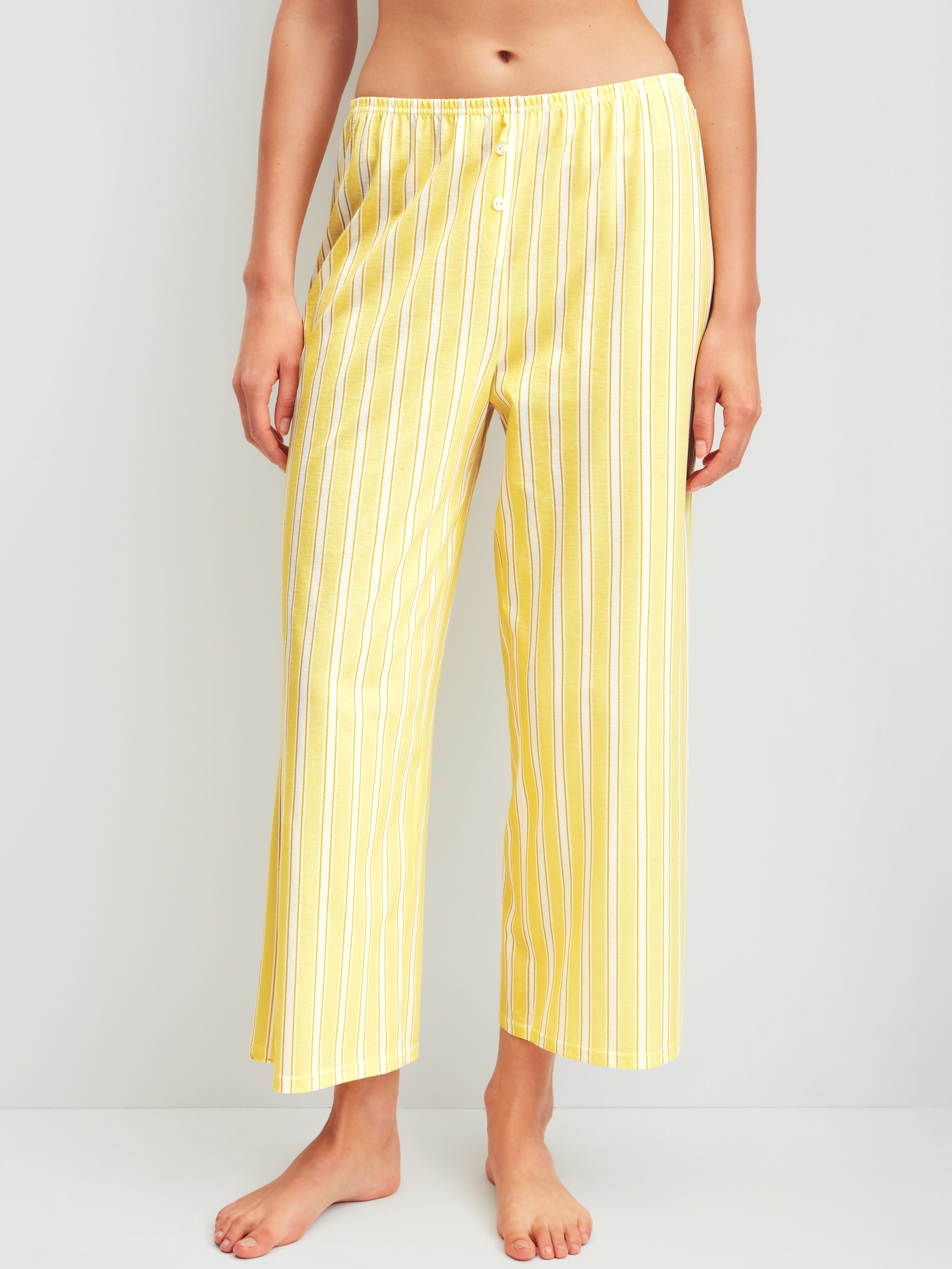 Women model is wearing 7/8 pyjama trousers made of 100% Cotton in Yellow, Striped from the Favourites Ocean series by CALIDA, Front view