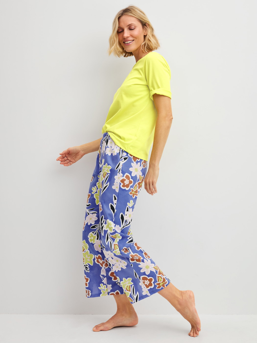 La modella / Il modello Donna indossa 7/8 Pantaloni pigiama in 100% cotone di colore Blu, Floreale, della serie Late Bloom M&M di CALIDA, Abbigliamento