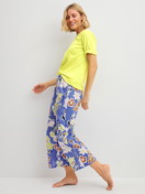 La modella / Il modello Donna indossa 7/8 Pantaloni pigiama in 100% cotone di colore Blu, Floreale, della serie Late Bloom M&M di CALIDA, Abbigliamento