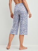 Damen-Model trägt 3/4-Pyjamahose aus 100% Baumwolle in Blau, Floral aus Serie Sleep Over M&M von CALIDA, Rückansicht