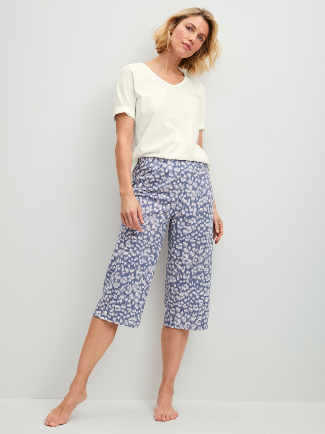 Damen-Model trägt 3/4-Pyjamahose aus 100% Baumwolle in Blau, Floral aus Serie Sleep Over M&M von CALIDA, Outfit